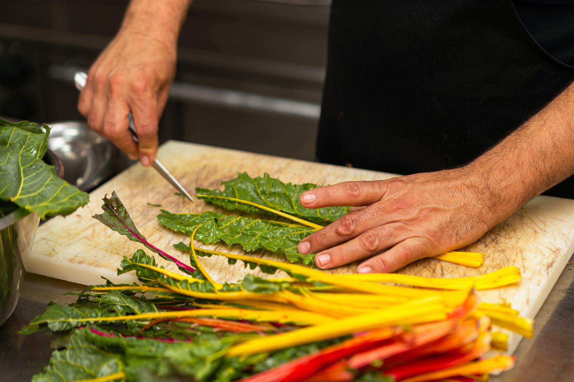 chef arranging fresh vegetables in workshop kitchen